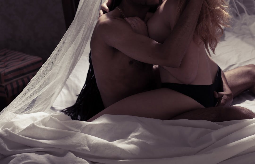 girl kissing boyfriend on bed
