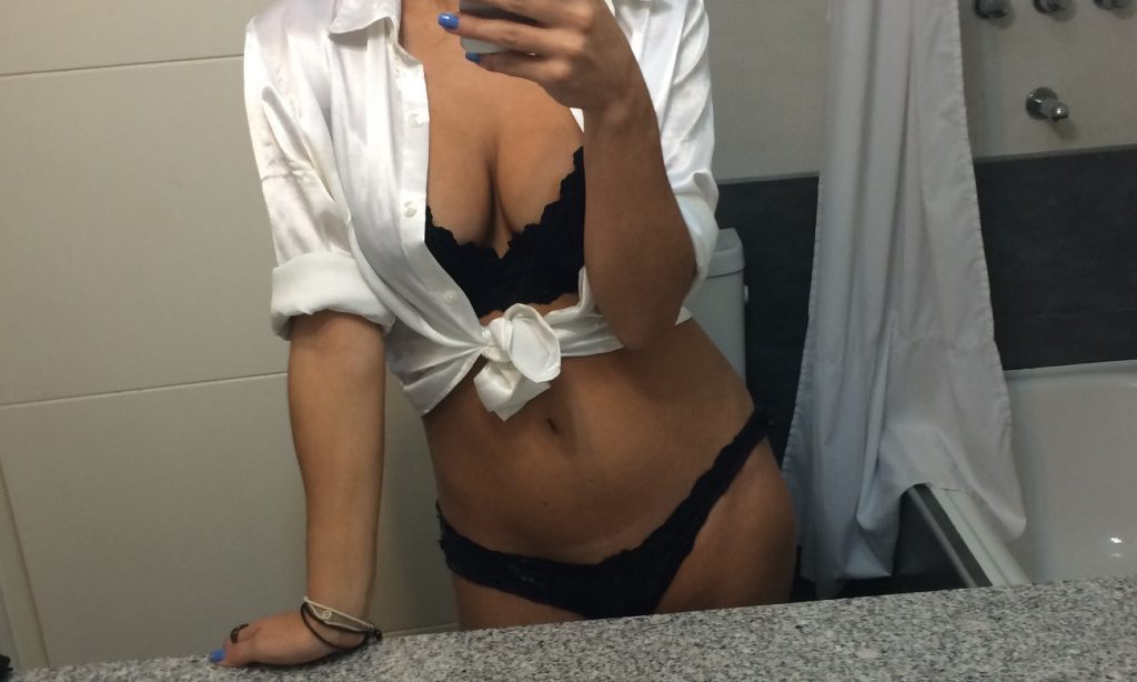 woman taking sexy mirror selfie in lingerie and shirt